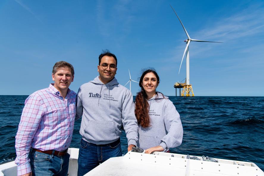 People on a boat with an offshore wind turbine in the background