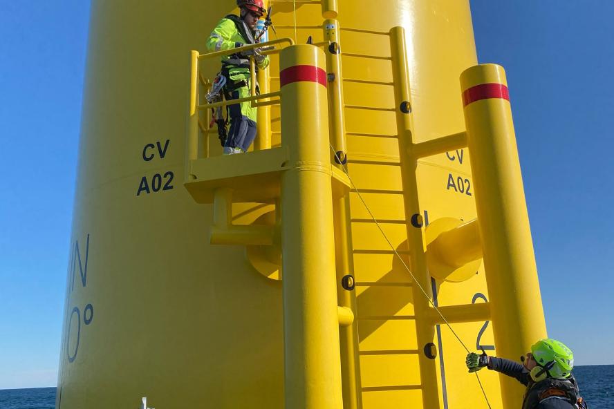 Workers climbing offshore wind turbine transition piece