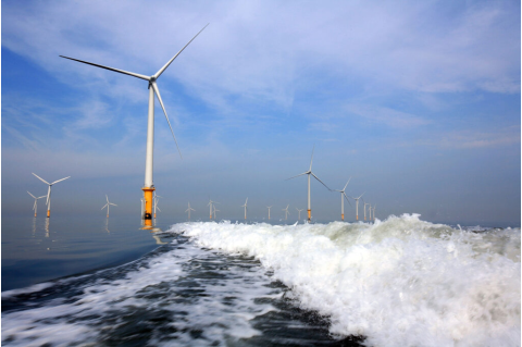 Turbines of the new Burbo Bank offshore wind farm lay in the wake of a maintenance boat in the mouth of the River Mersey in Liverpool, England